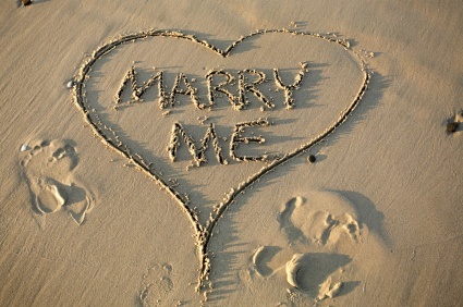 Marry Me written in a heart in the sand on a beach