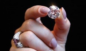 woman with engagement ring holding diamond