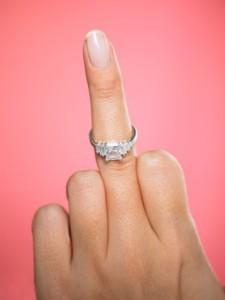 Hand with engagement ring making obscene gesture, middle finger