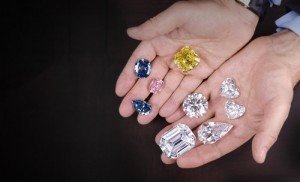 man holding diamonds of different colours