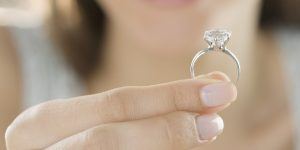 Woman holding beautiful diamond engagement ring