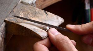 Jeweller repairing diamond ring in workshop
