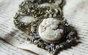 old fashioned cameo necklace on written paper